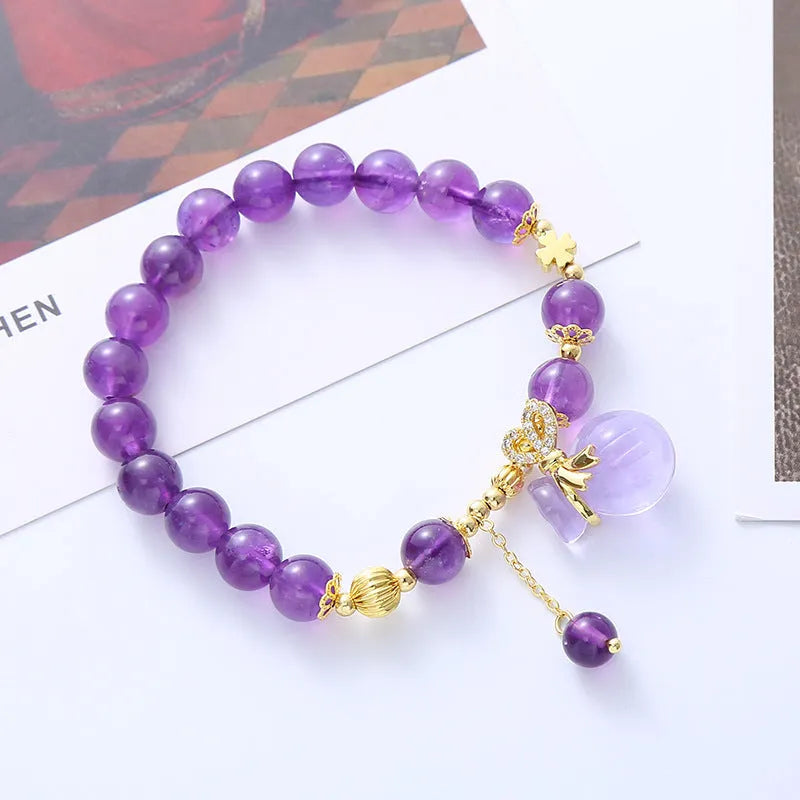 Purple amethyst bracelet with ethnic money bag pendant and peace buckle closure on wrist