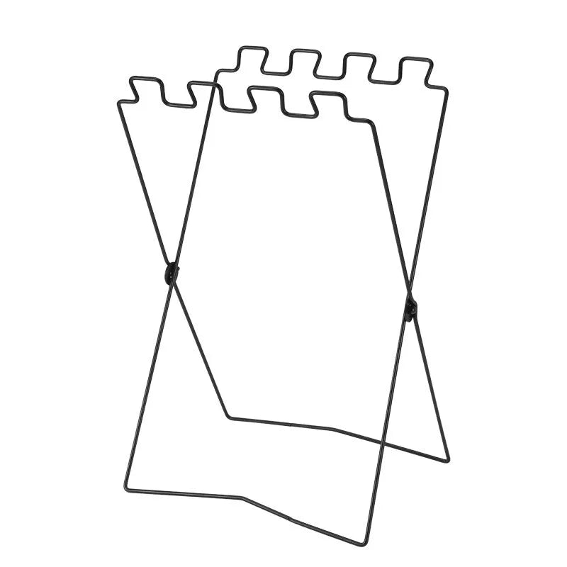 Silver folding stainless steel garbage bag holder bracket on a wooden surface.