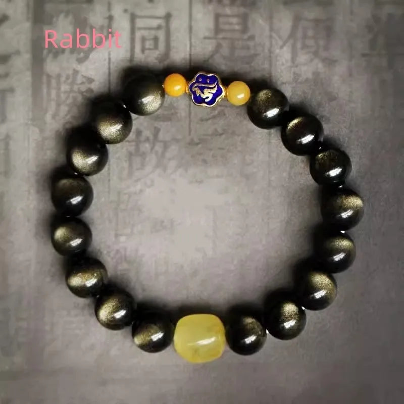 Golden obsidian bracelet with carved zodiac symbols on geometric beads