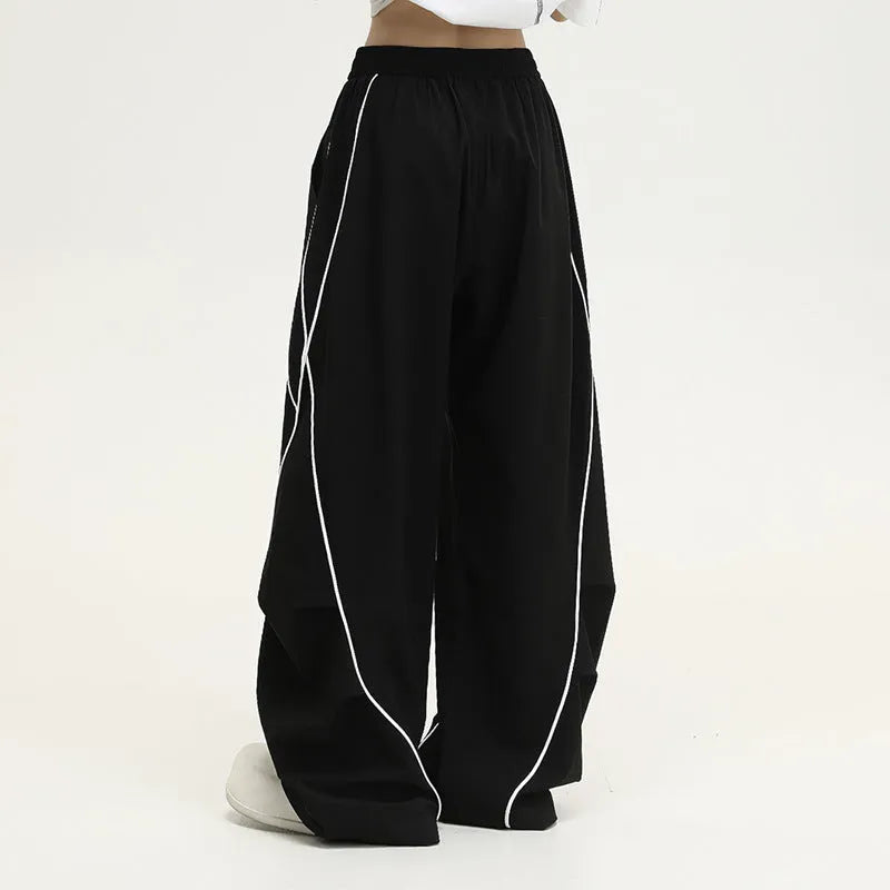 Black striped pleated wide-leg hip hop trousers on hanger showing mid-waist design