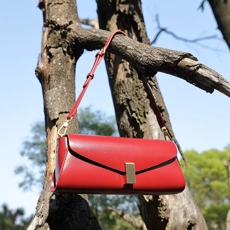 Women's cowhide leather cross-body bag in pillow shape with clamshell opening, shown in milky white colour