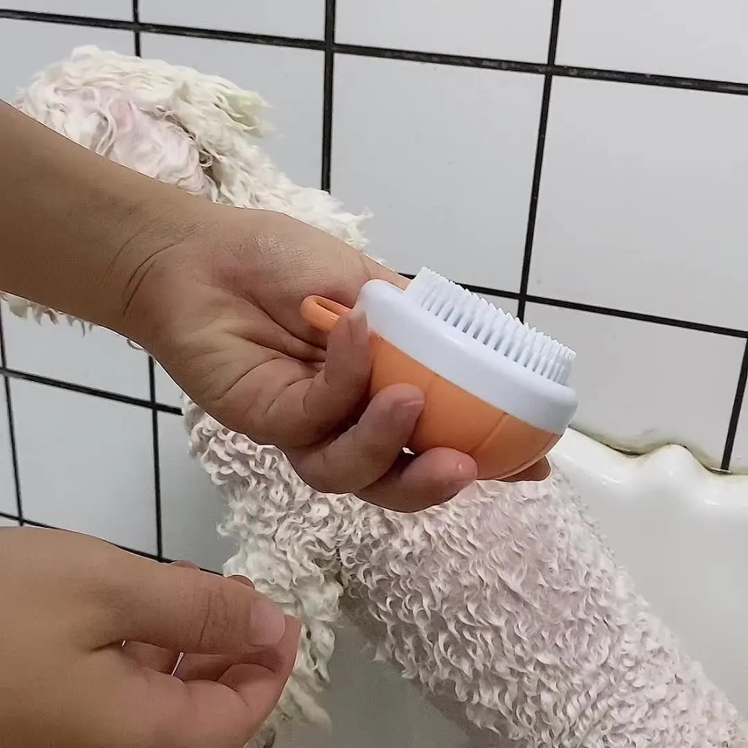 Orange dog bath brush with shampoo dispenser and soft TPR bristles for pet grooming