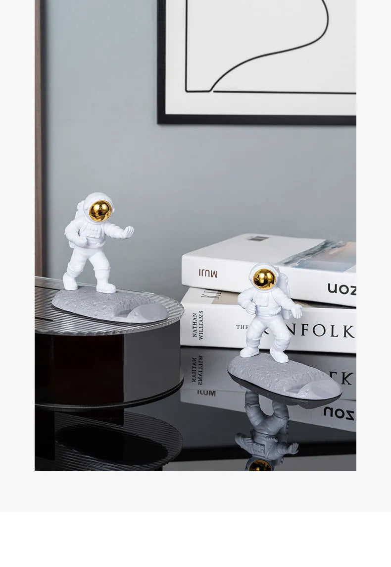 Plastic astronaut decoration mobile phone holder in blue colour on a desk