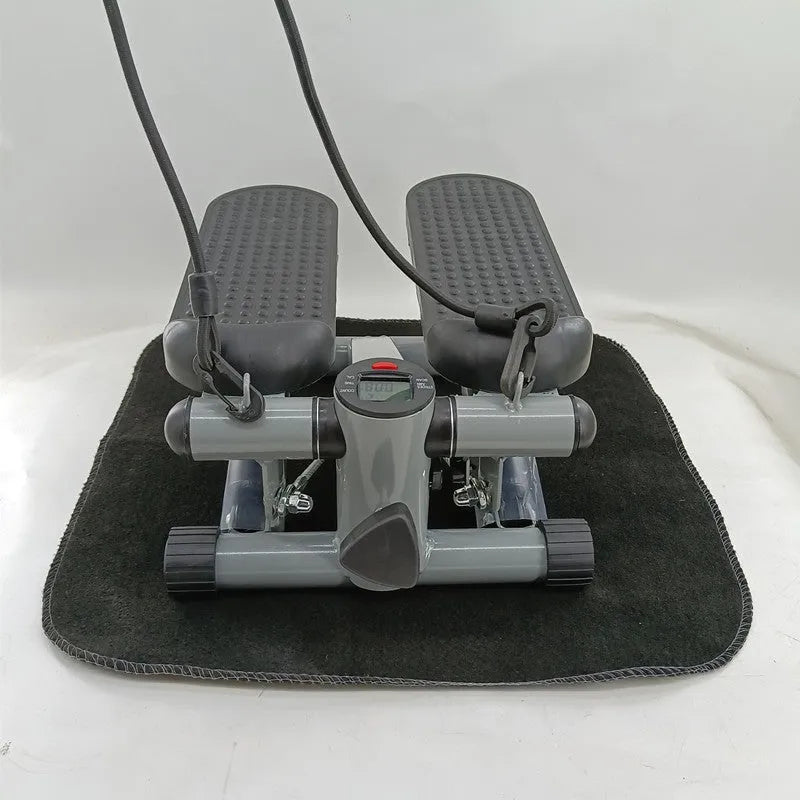 Silver grey hydraulic mini treadmill for waist slimming exercises in a home setting.