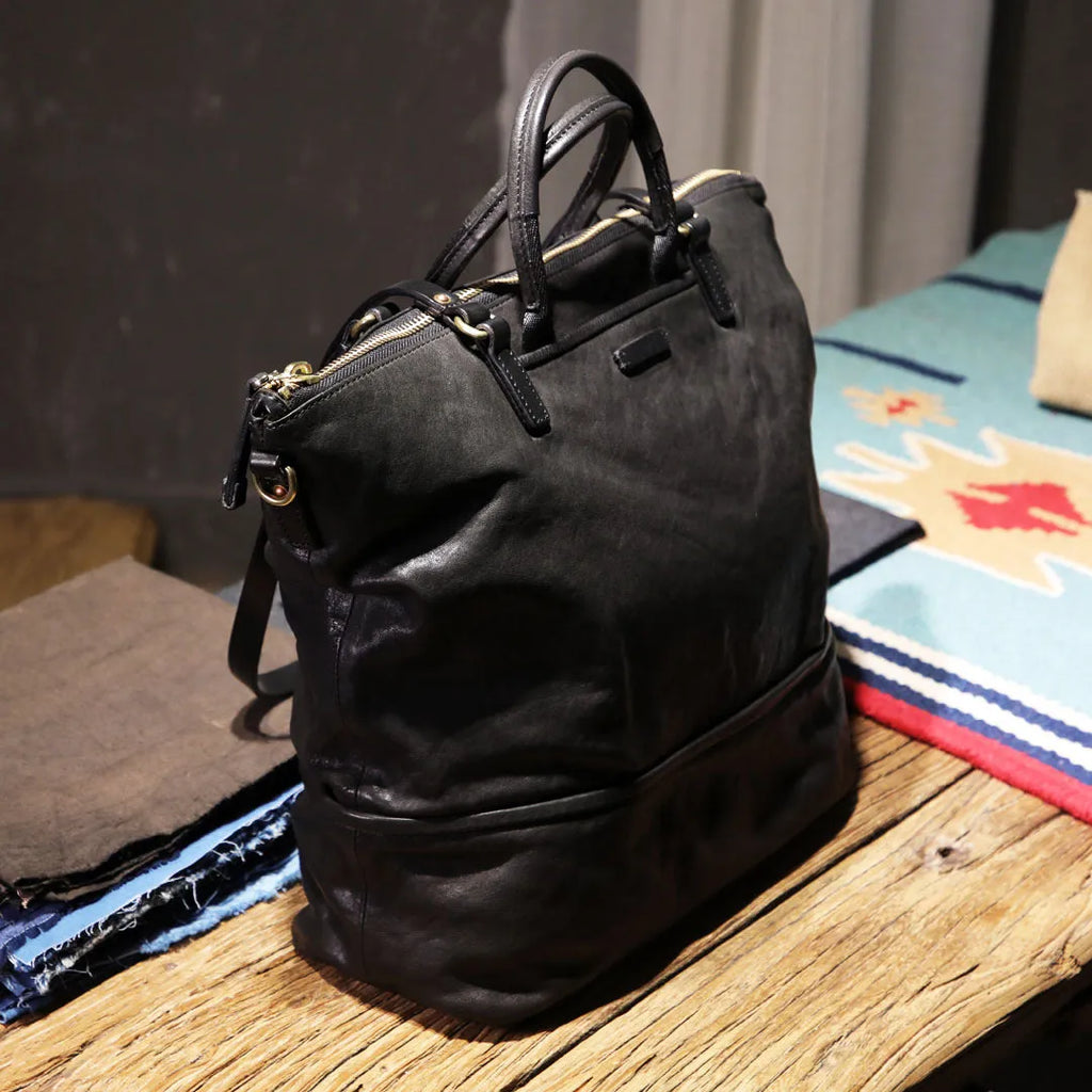 Black handmade vegetable tanned cowhide tote bag with zipper closure and 15-inch computer slot for daily outdoor use