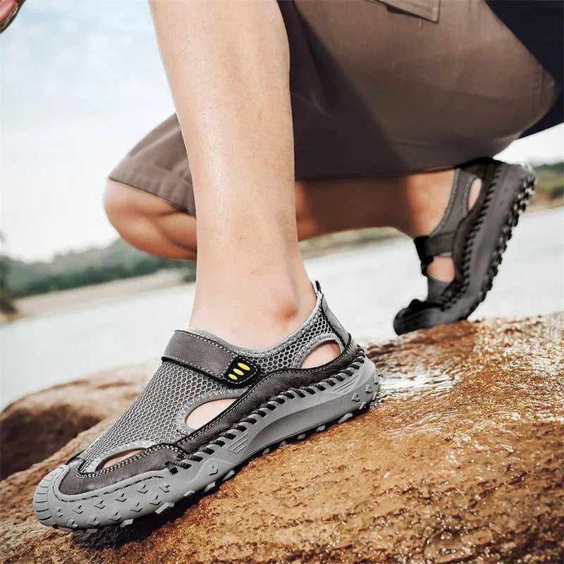 Men's black casual sandals with a mesh upper and velcro strap on a rubber sole.