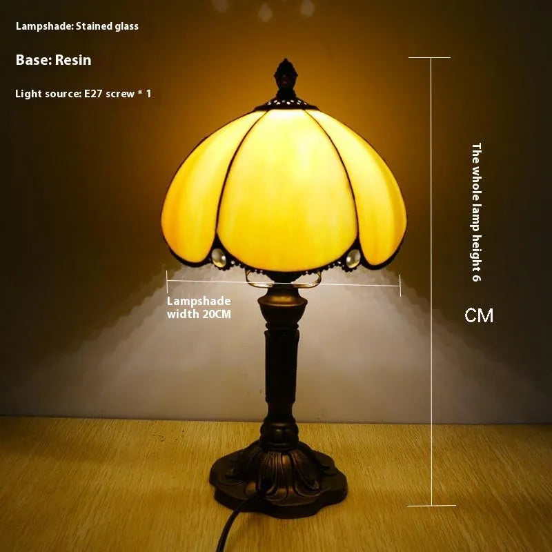 Modern minimalist beige coloured bedside lamp with a width of 20cm on a table.