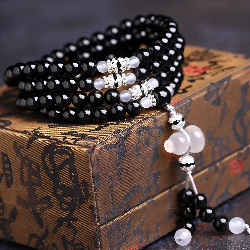 Natural black agate 108 bead bracelet with 8mm geometric beads on a wrist.