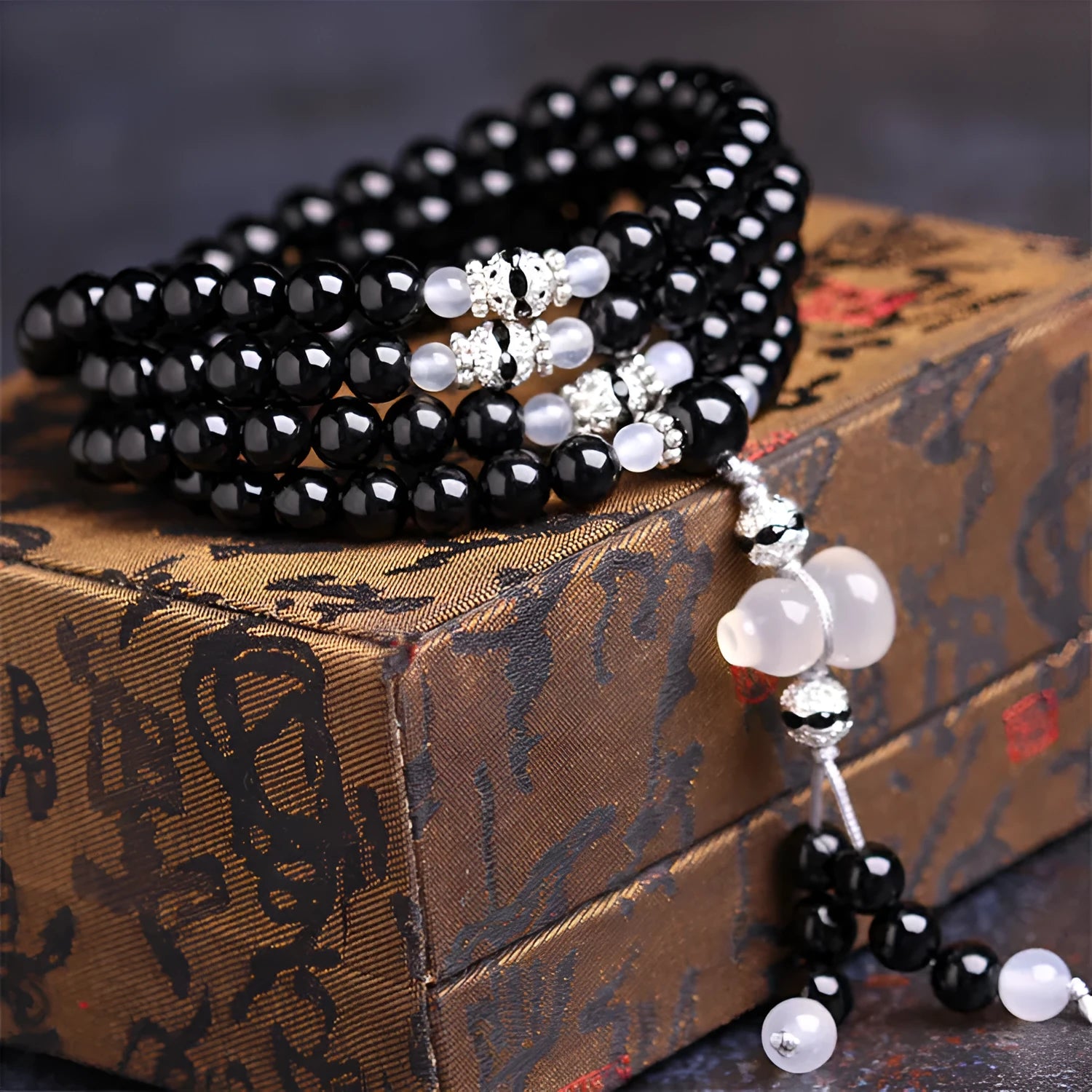 Natural black agate 108 bead bracelet with 8mm geometric beads on a wrist.