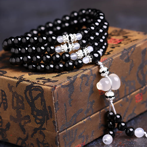 Natural black agate 108 bead bracelet with 8mm geometric beads on a wrist.