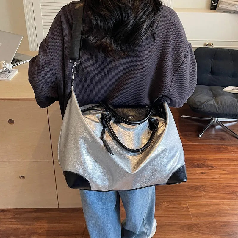 Women's hand-carry travel bag in black or silver with 36-55 litre capacity and PU material construction