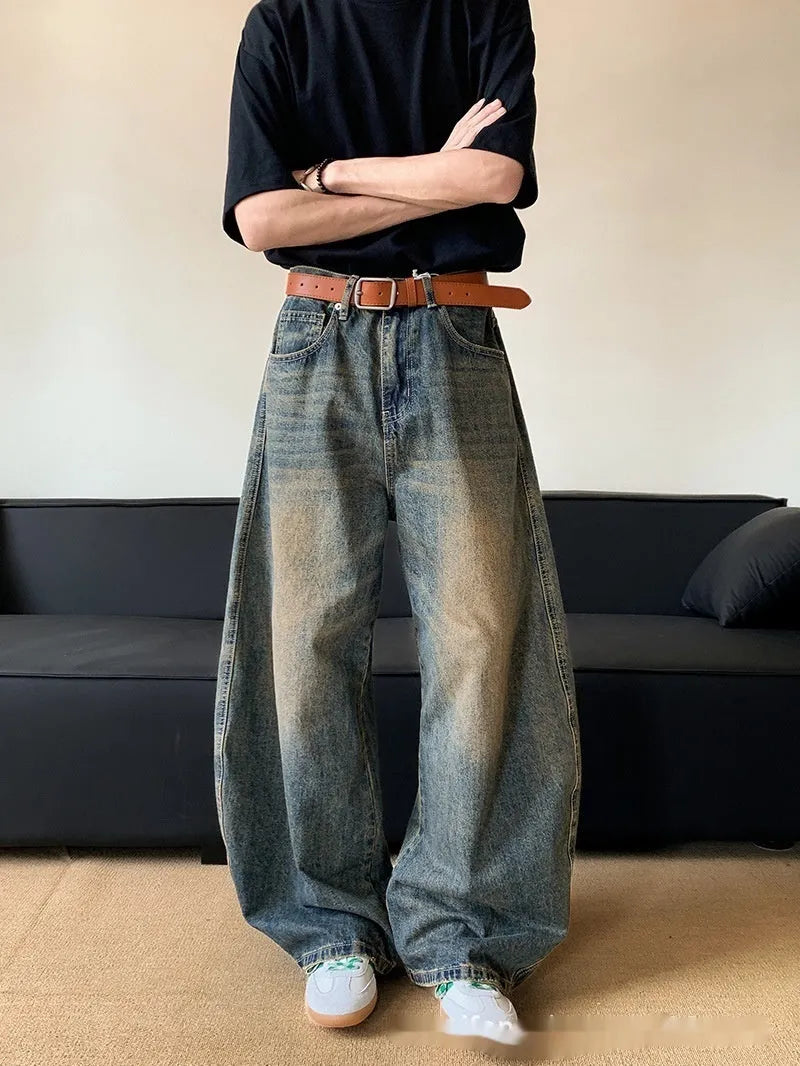 Men's retro blue distressed denim jeans with a slimming wide-leg fit and machete wash detail.