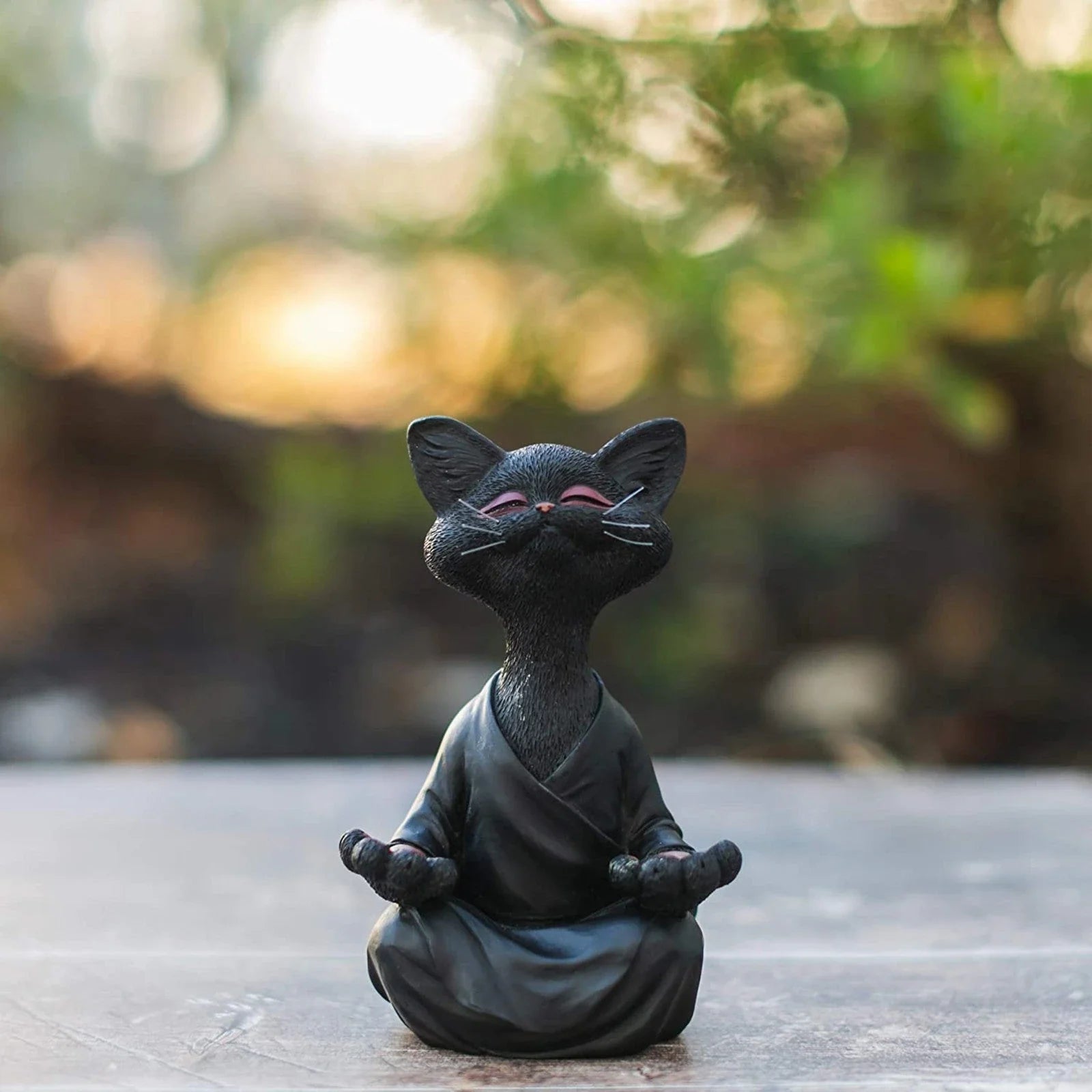 Charming ceramic Buddha cat figurine in black, grey, and orange colors for meditation, yoga, and home decor