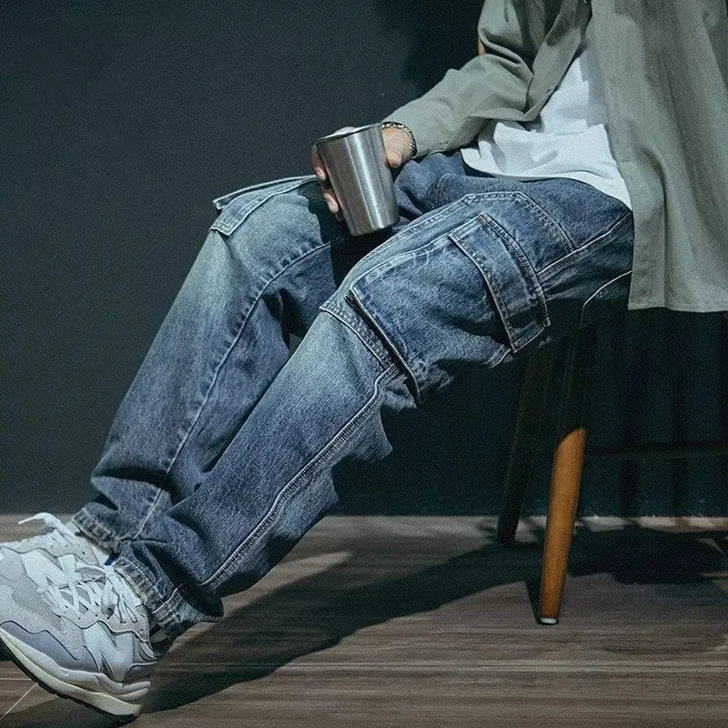 Men's blue loose straight leg jeans with a zip fly on a plain background.