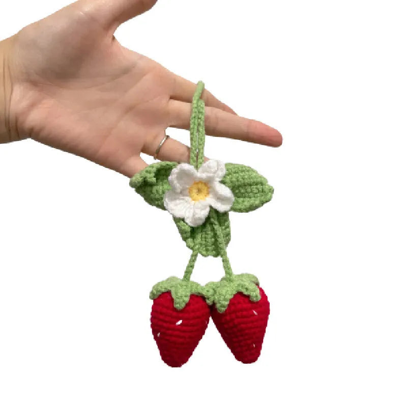 Handmade woven strawberry-shaped car pendant decoration in natural cotton and hemp fibres.