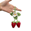 Handmade woven strawberry-shaped car pendant decoration in natural cotton and hemp fibres.