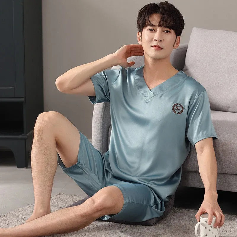 Man wearing a light blue loose short-sleeved ice silk pajama shirt and matching shorts.