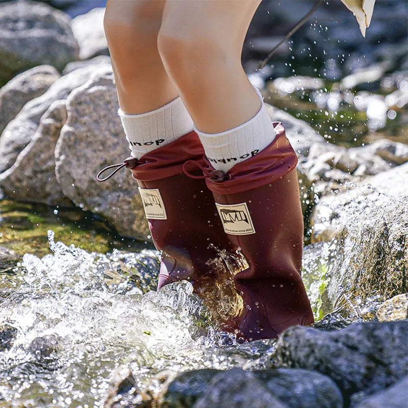 Pair of solid-colour high-tube PVC rain boots with a non-slip sole on a neutral background.