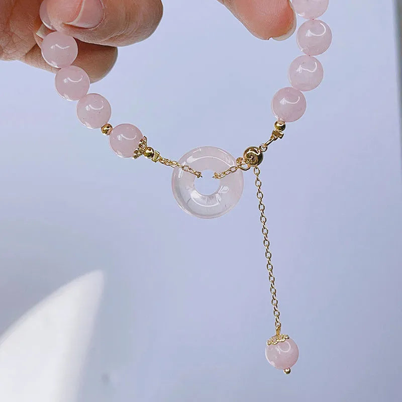 Pink crystal peace buckle bracelet on a metallic chain for women.