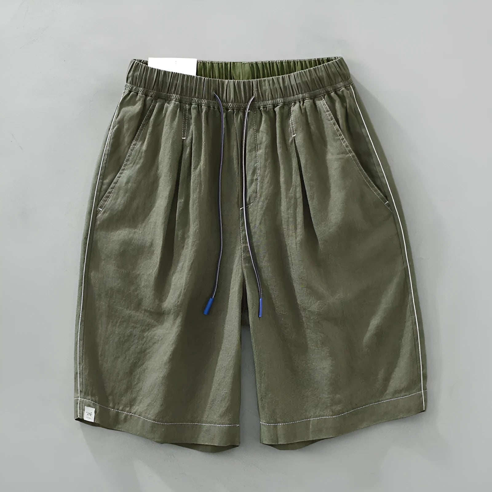 Men's loose straight fit linen shorts in green with drawstring waist, shown laid flat