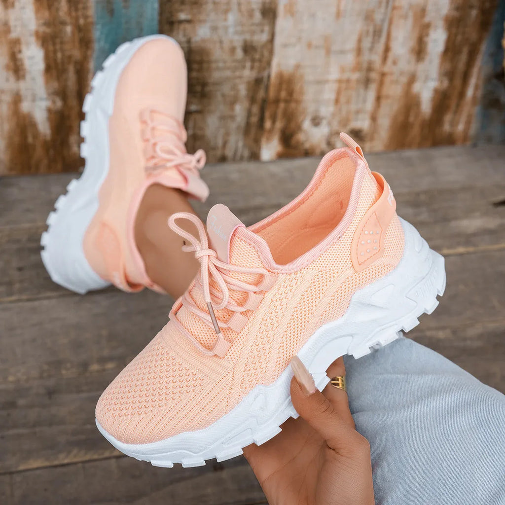 Women's white Flyknit mesh casual sports shoes with flat heel and lace-up front on a neutral background.