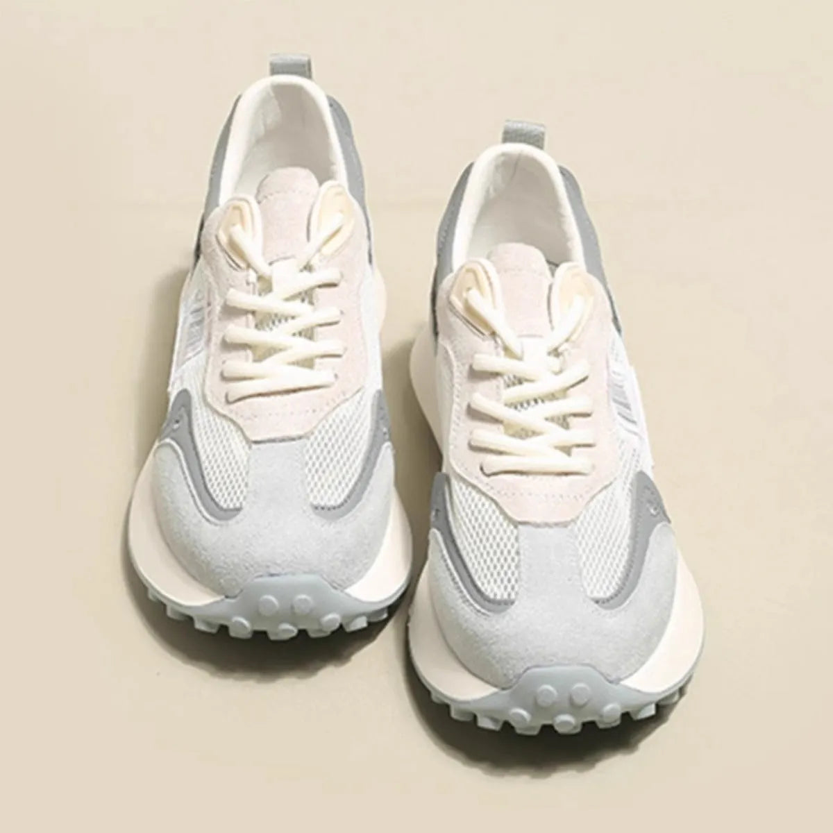 Women's low-top retro sneaker in grey or pink with round toe and rubber sole.