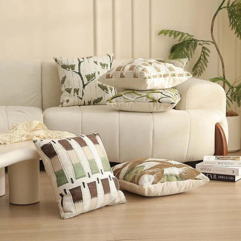 Square jacquard cushion cover with a detailed woven botanical pattern in a retro colour, shown on a grey sofa.