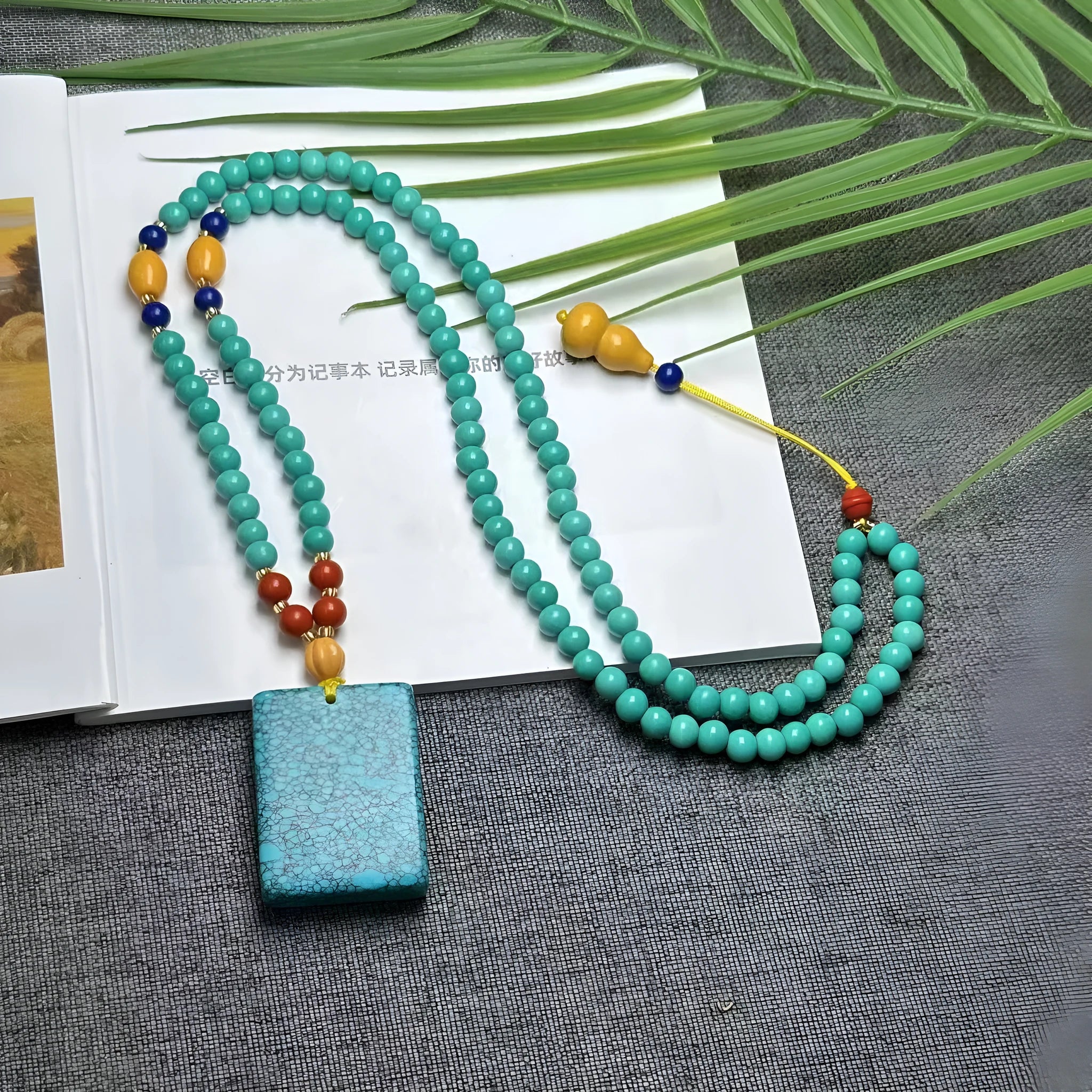 Turquoise mesh flower pendant on an adjustable ball bead necklace chain.