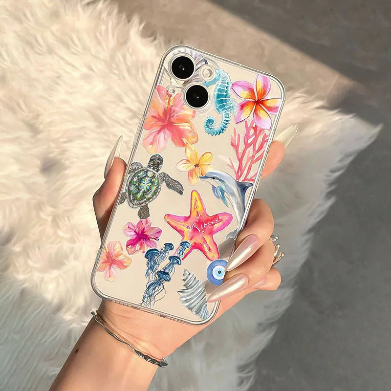 Transparent TPU iPhone case with painted dolphin and turtle design on a phone.
