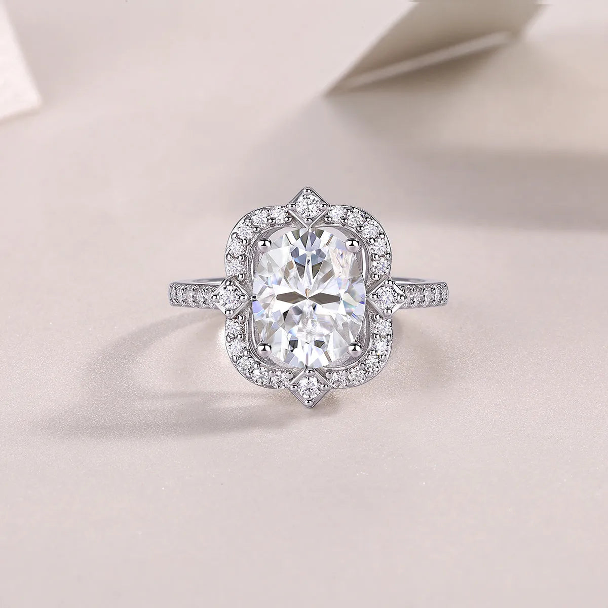 Egg-shaped moissanite ring set with S925 silver and platinum plating on a white surface