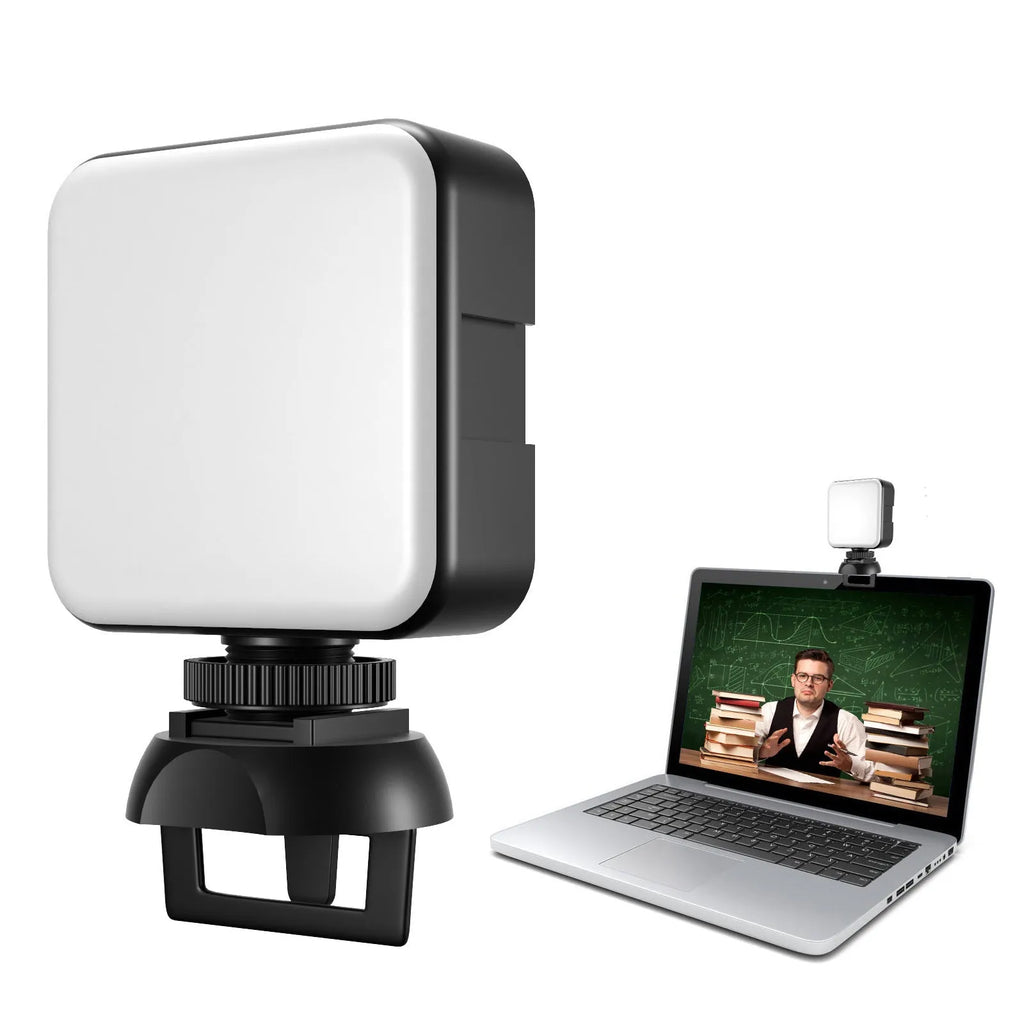 Silver 5600K LED video light cube clipped onto a laptop, with shelf and wire included