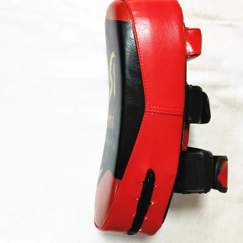 Black and red square martial arts training pad held in hand, showing double buckle strap.