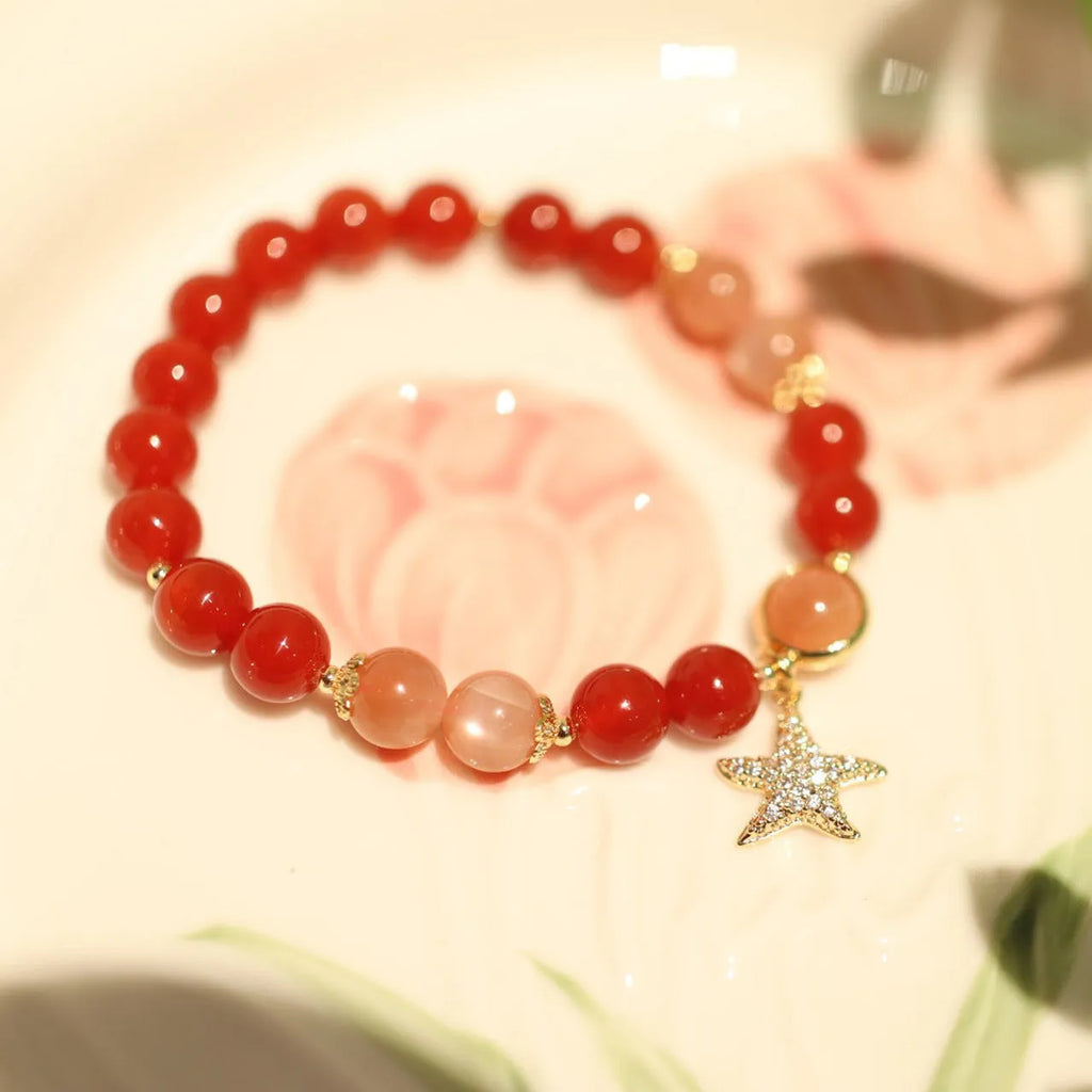 Handmade women's bracelet with 8mm red agate and sunstone beads in ethnic XINGX design featuring star and xiangyun elements
