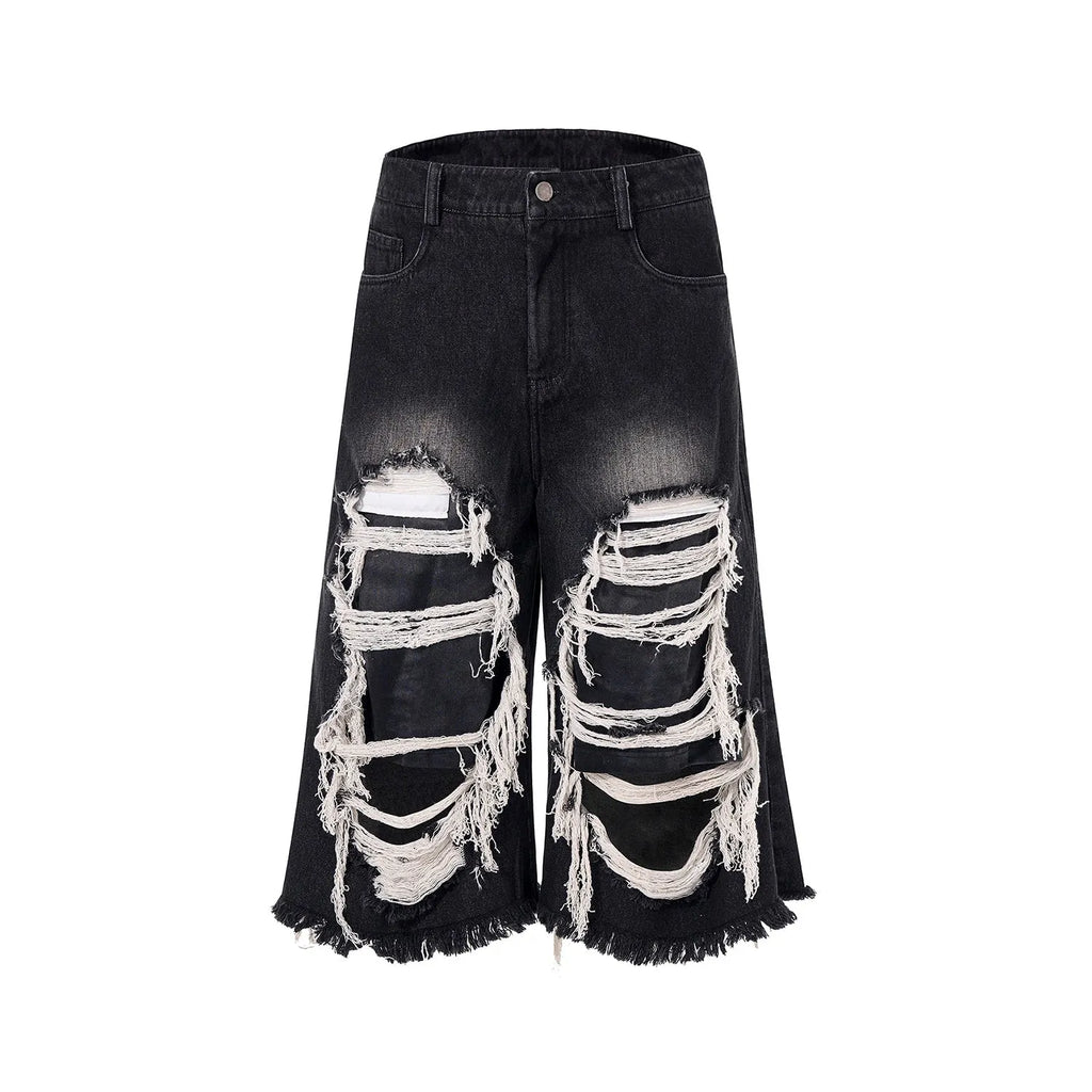 Black wide-leg cropped jeans with a ripped patch detail on the leg, showing a mid-high waist and loose fit.