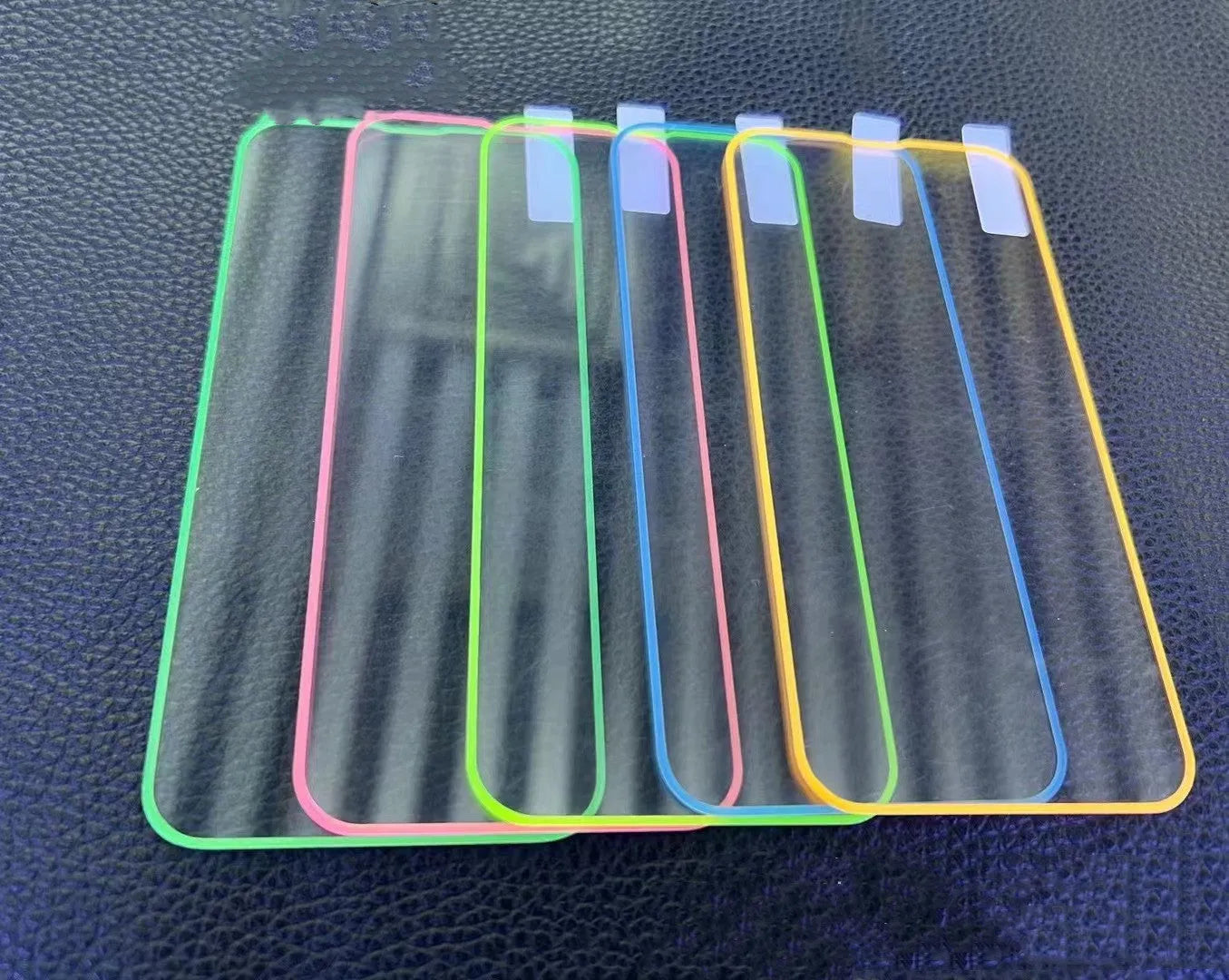 Fluorescent luminous tempered glass screen protector for iPhone in pink, yellow, green, blue, and grass green colours.