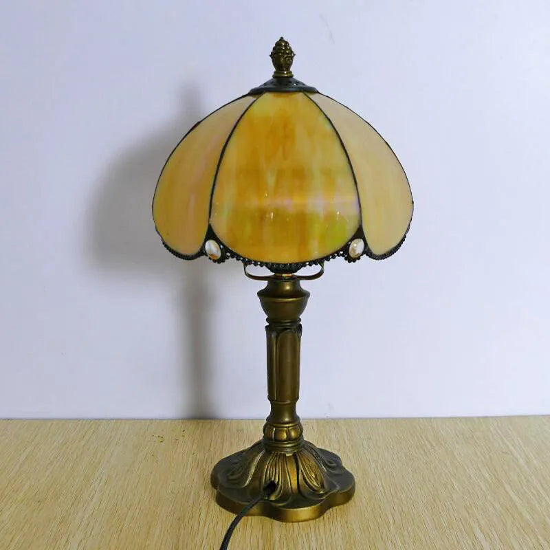 Modern minimalist beige coloured bedside lamp with a width of 20cm on a table.