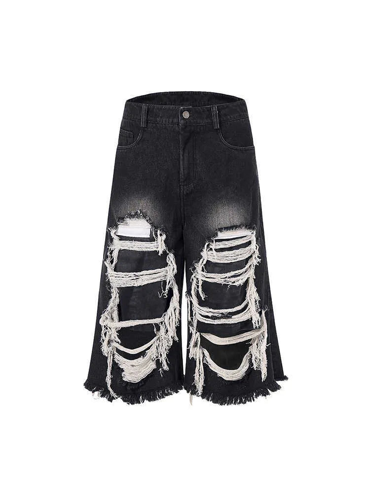 Black wide-leg cropped jeans with a ripped patch detail on the leg, showing a mid-high waist and loose fit.