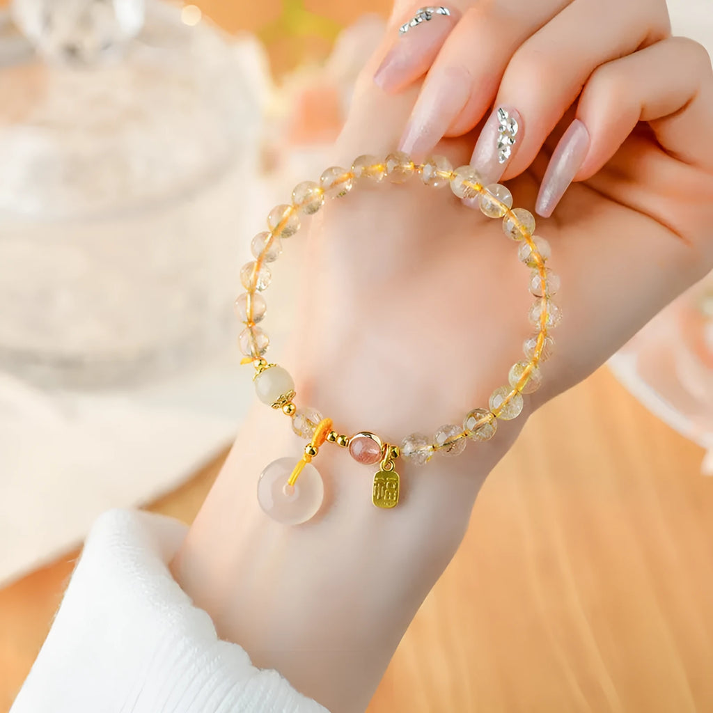 Gold rutilated quartz crystal bracelet with peace buckle closure and blessing card pendant