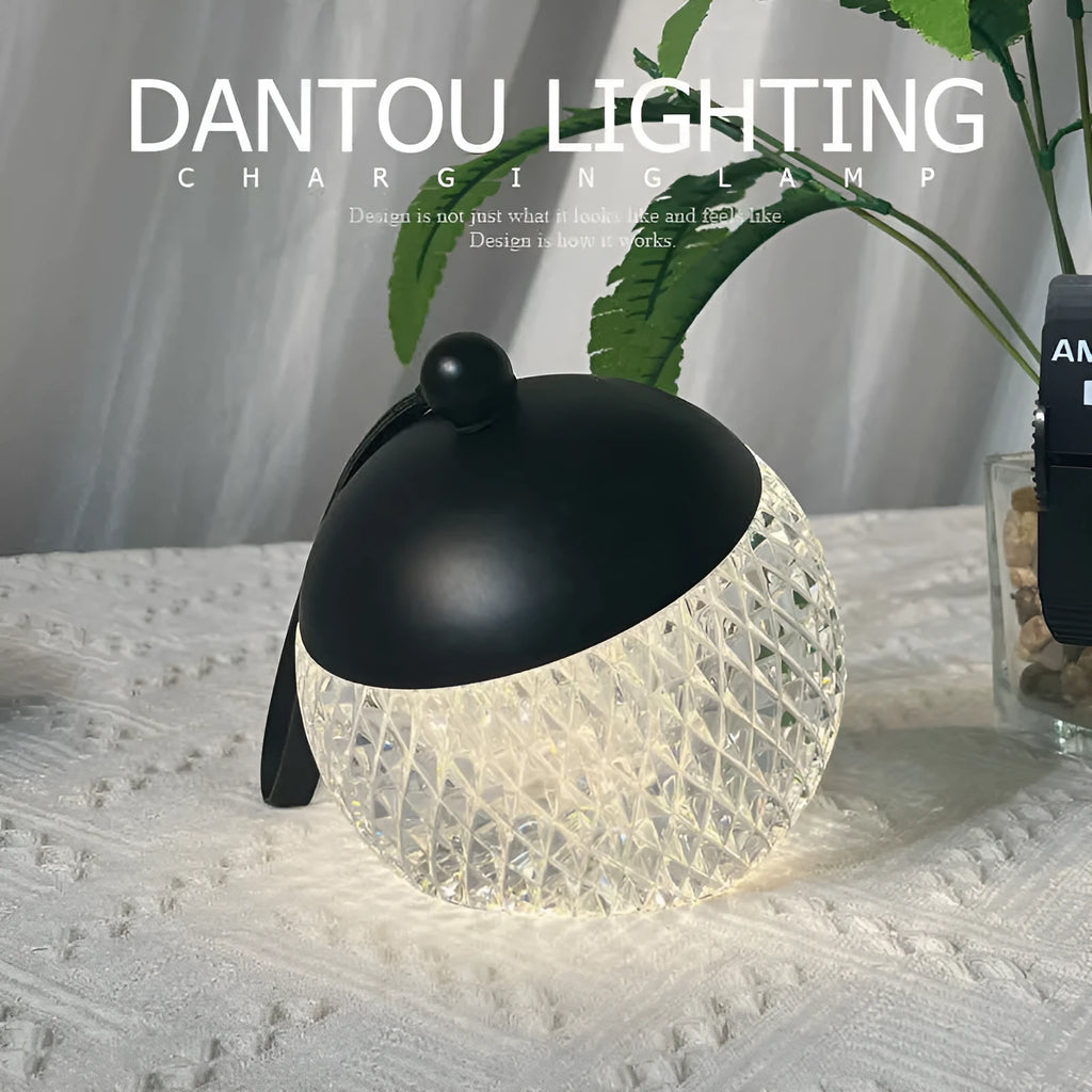 Small cylindrical portable night lamp with touch dimmer in chrome, gold, black, coppery brown, or white finish.