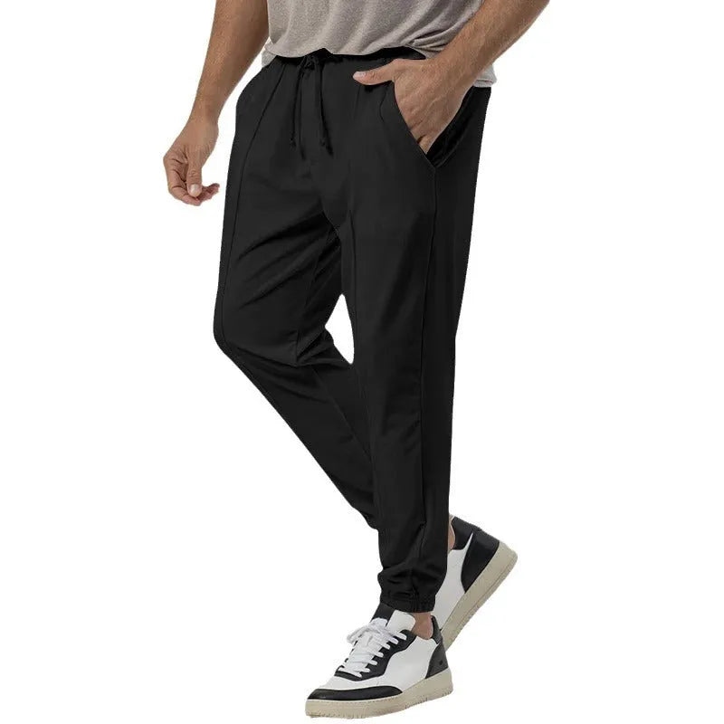 Men's grey cotton blend track sweatpants with a loose tapered fit and straight leg on a mannequin.