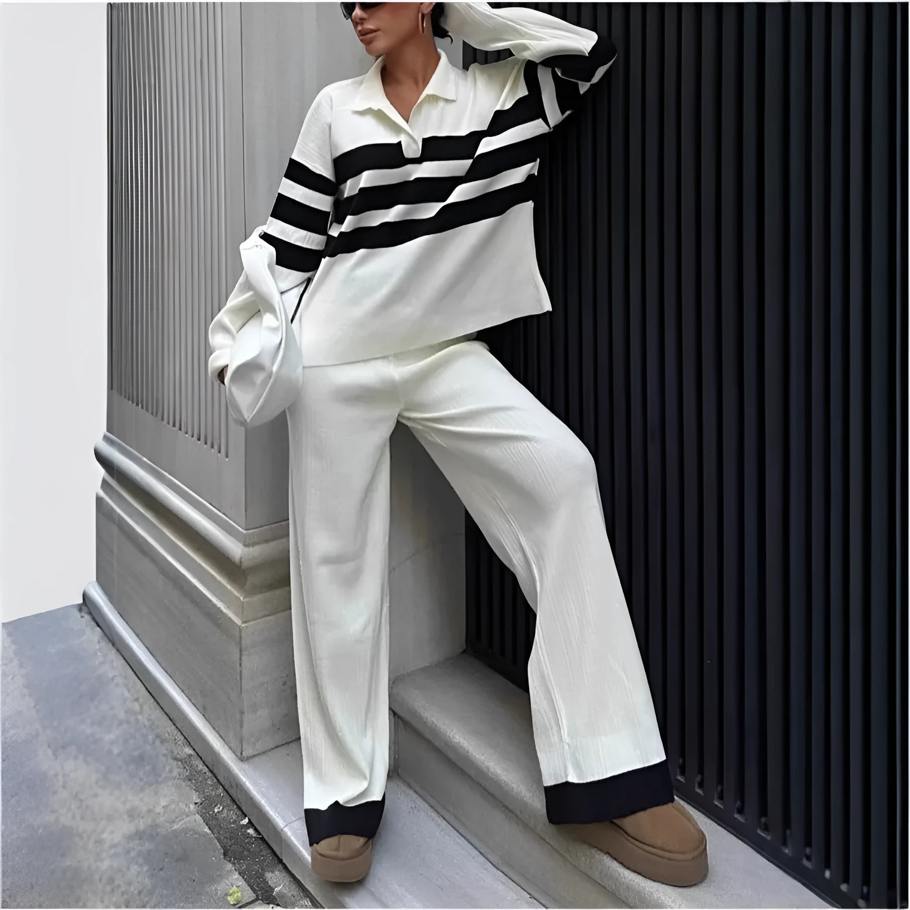 Women's black and white striped knitted polo shirt with matching trousers, a casual two-piece set.