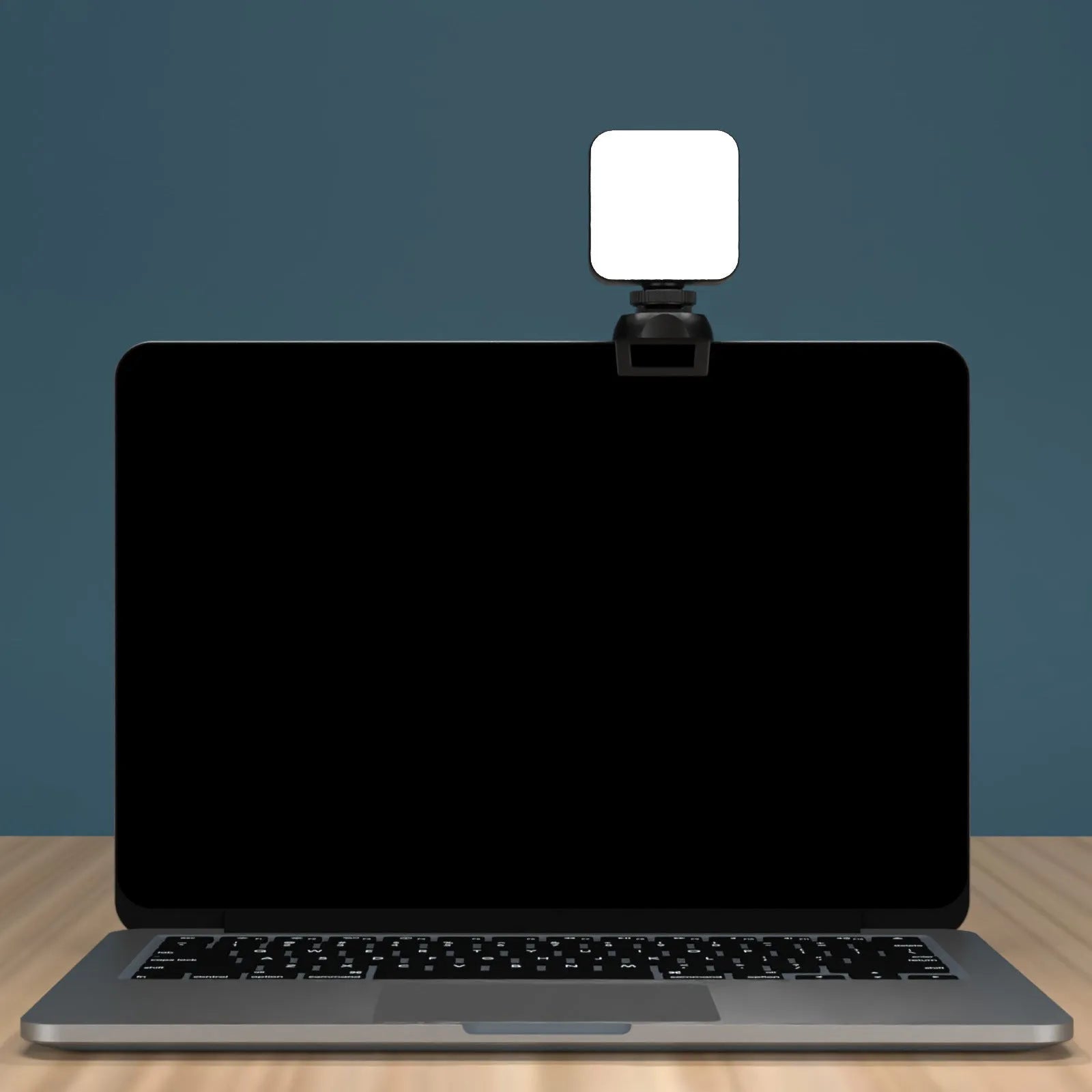 Silver 5600K LED video light cube clipped onto a laptop, with shelf and wire included
