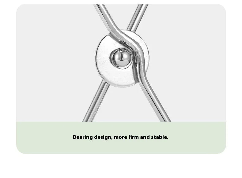 Silver folding stainless steel garbage bag holder bracket on a wooden surface.