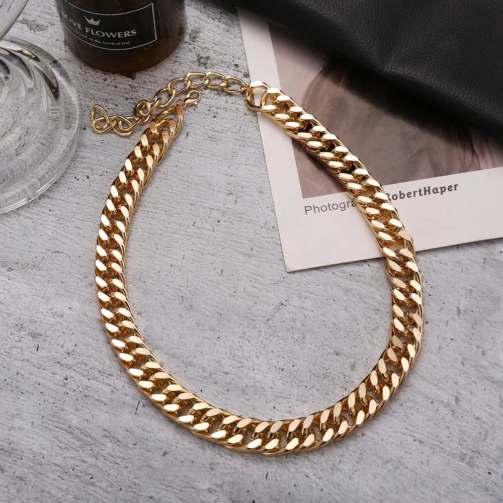 Gold coloured women's thick chain necklace on a white background.