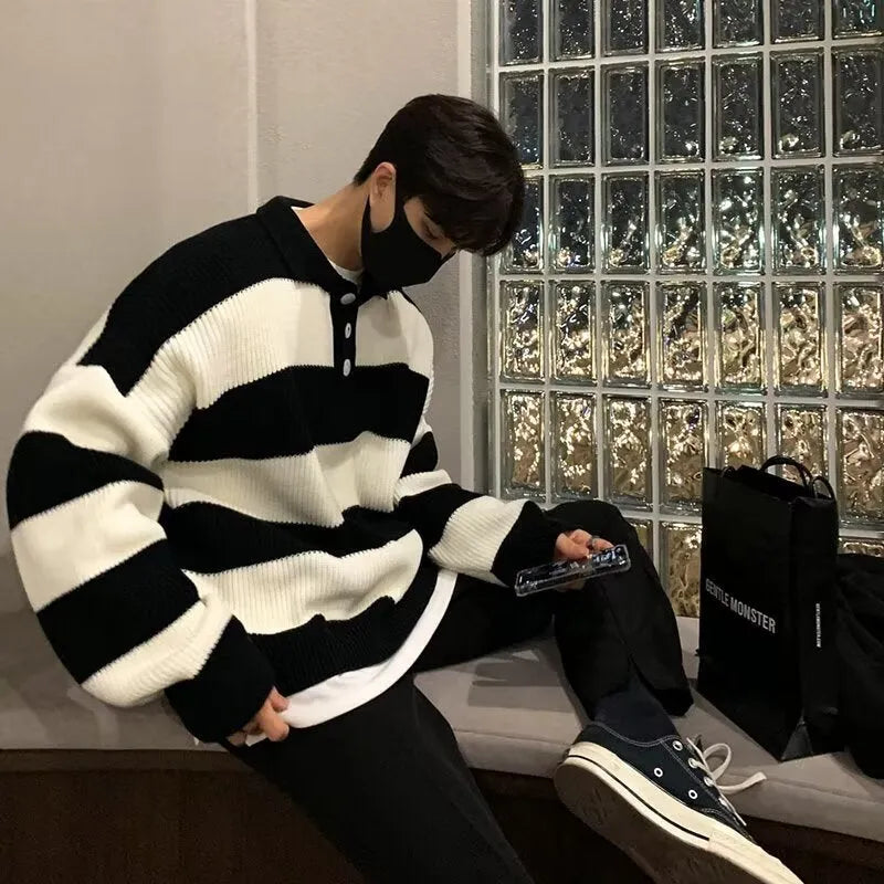 Man modelling a loose fit black and grey striped polyester sweater coat, long sleeve pullover style.