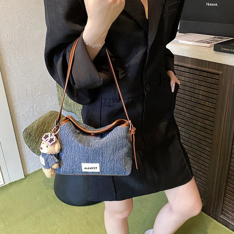 Denim small crossbody bag in black with slit pocket, horizontal square shape, medium hardness, polyester lining.