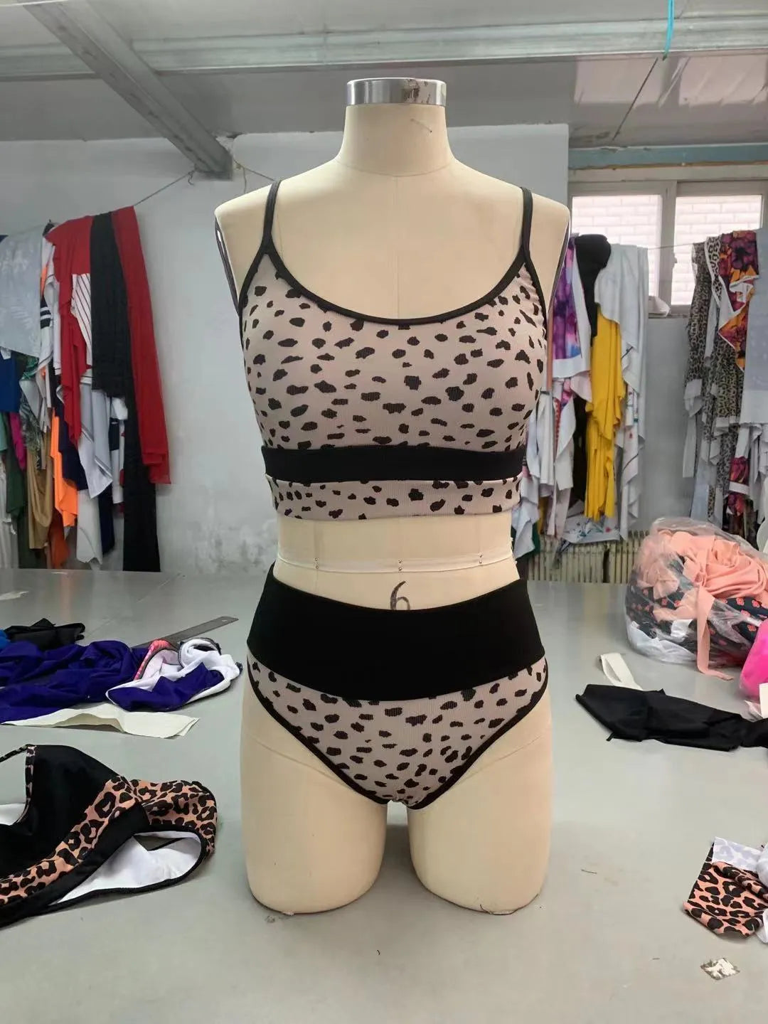 Women's white and leopard print high waist split bikini swimsuit with adjustable ties laid flat