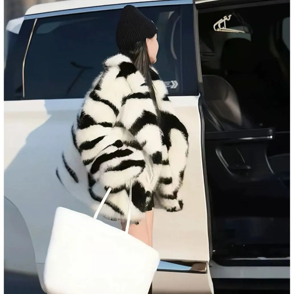 Zebra stripe patterned women's faux fur top with long sleeves and a skimmer collar.