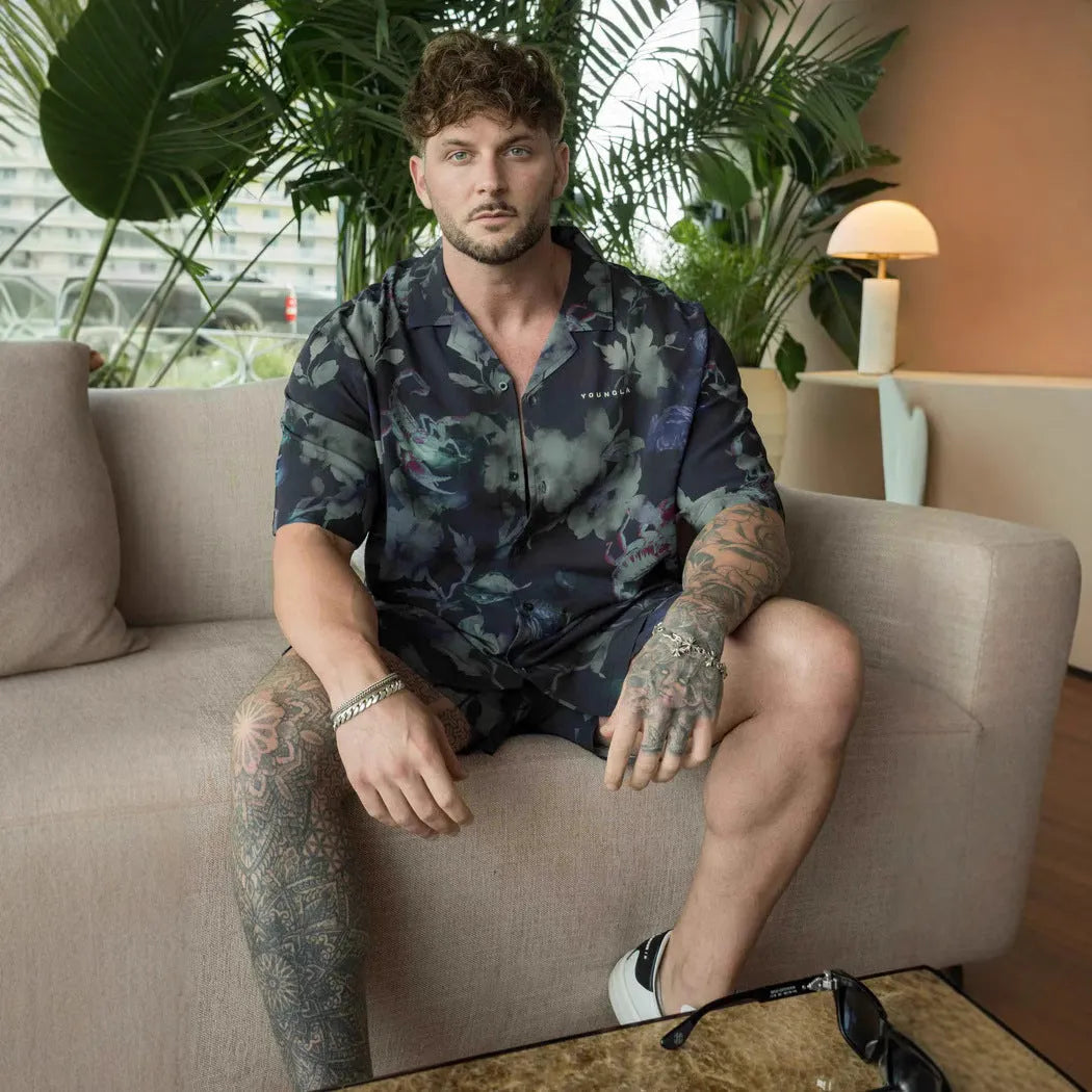 Man wearing a loose-fitting grey short-sleeve top with a floral print design.