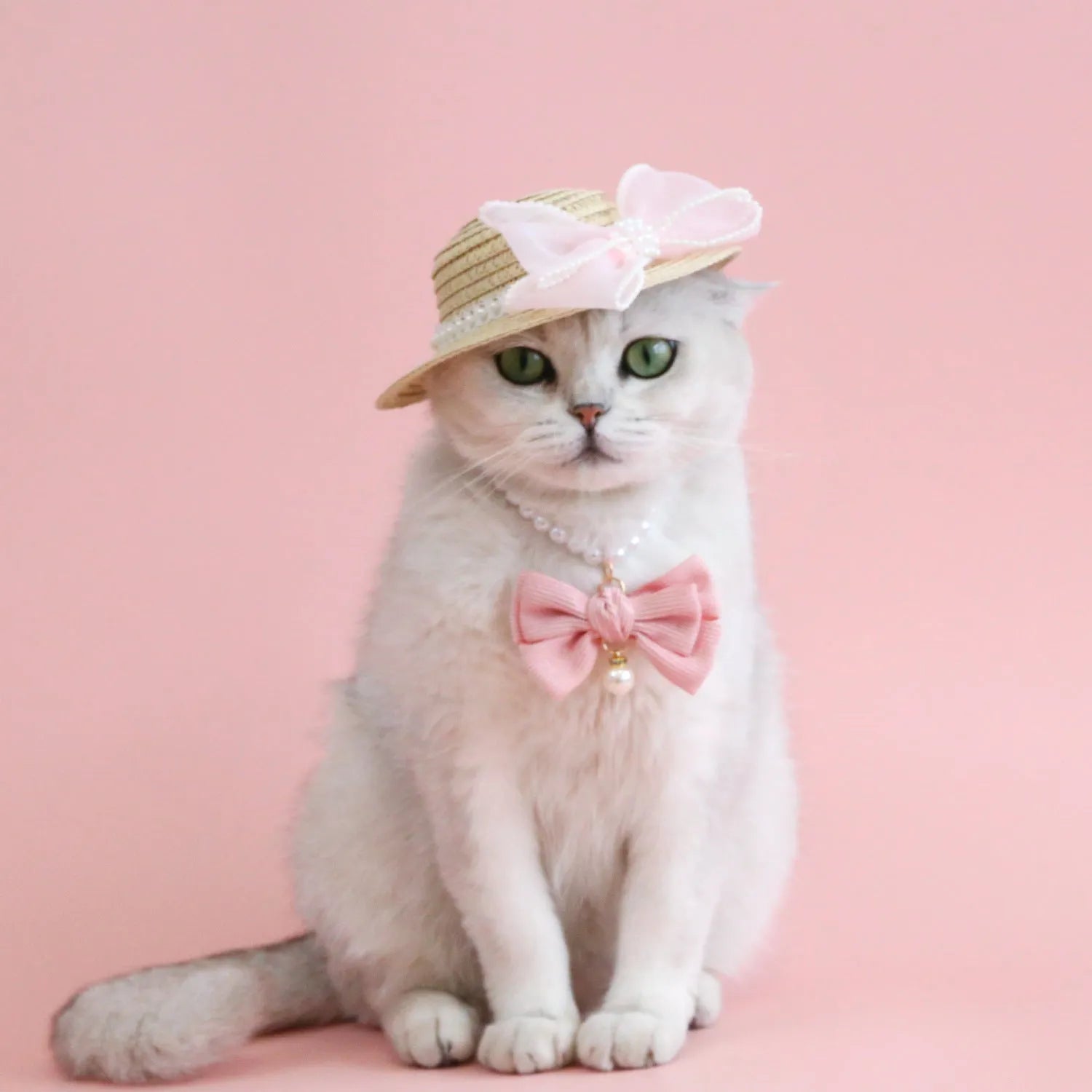 Pink pearl bow straw hat for a cat on a mannequin head, showing Lafite leaf weave and butterfly detail.